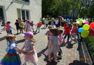 Dzieci tańczą na tarasie przedszkolnym w parach.